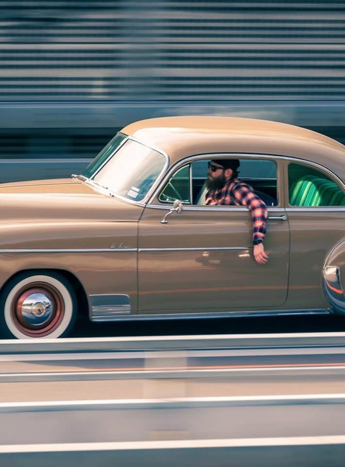 サングラスをかけた4人の女性が車内で笑顔を見せ、ドライブを楽しんでいる様子